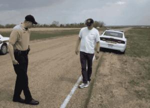 Police officer observing a man walking heelpto-toe on a road shoulder as part of a Walk-and-Turn field sobriety test