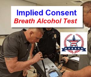 A police officer administering a post-arrest alcohol breath test with overlayed text: "Implied Consent Breath Alcohol Test"